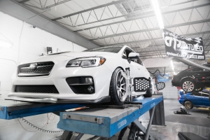White Subaru STi on alignment rack